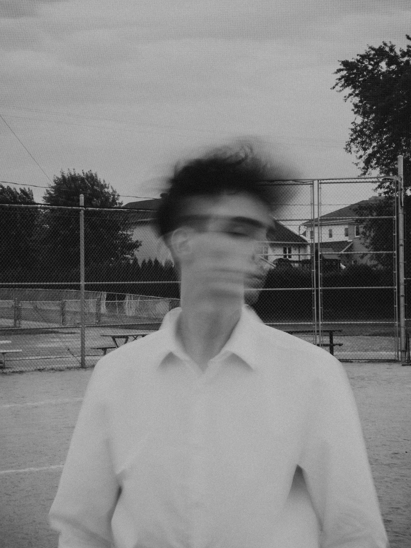 a blurred black and white image of a man shaking his head