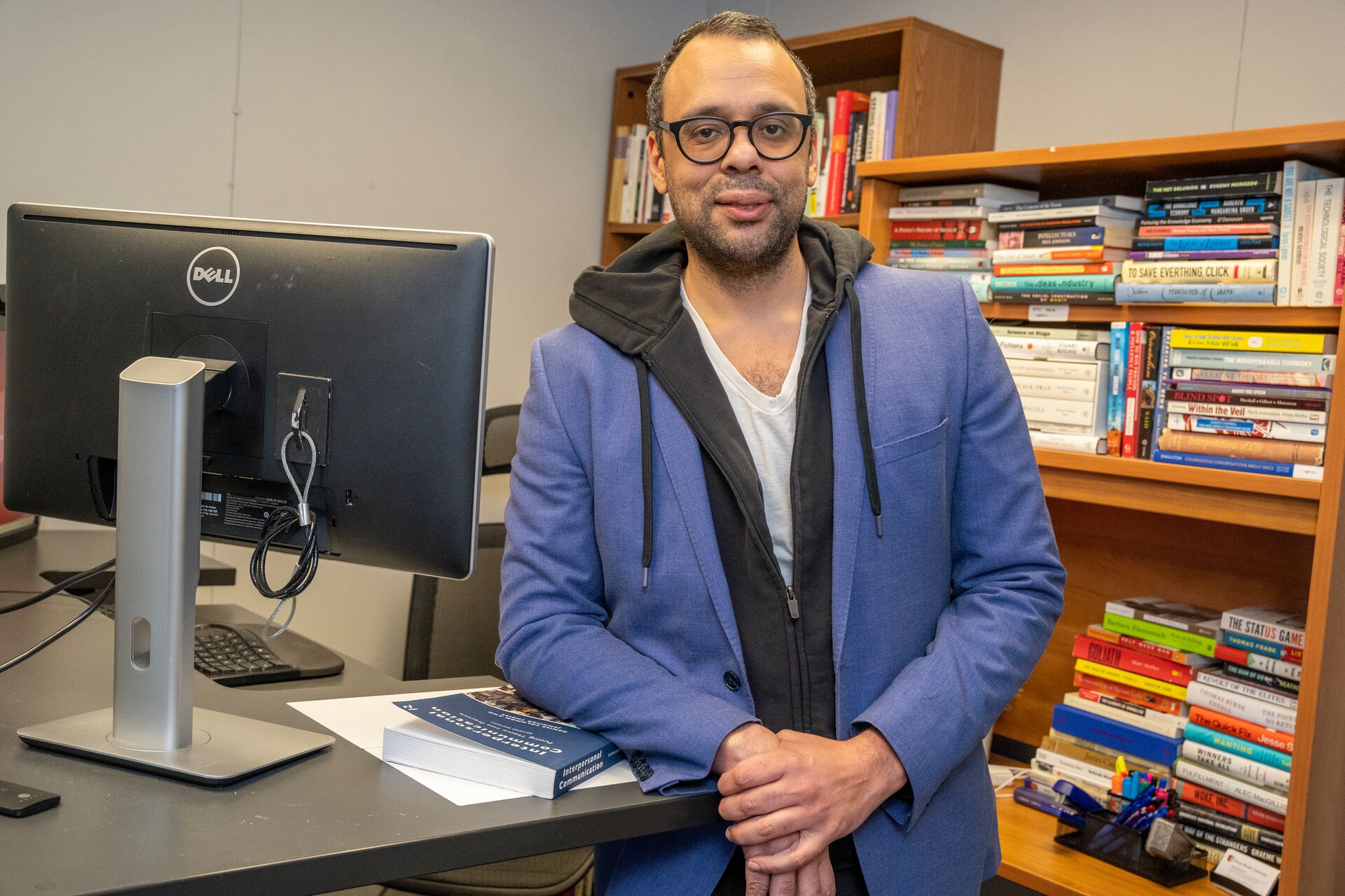 Musa al-Gharbi in front of bookshelf