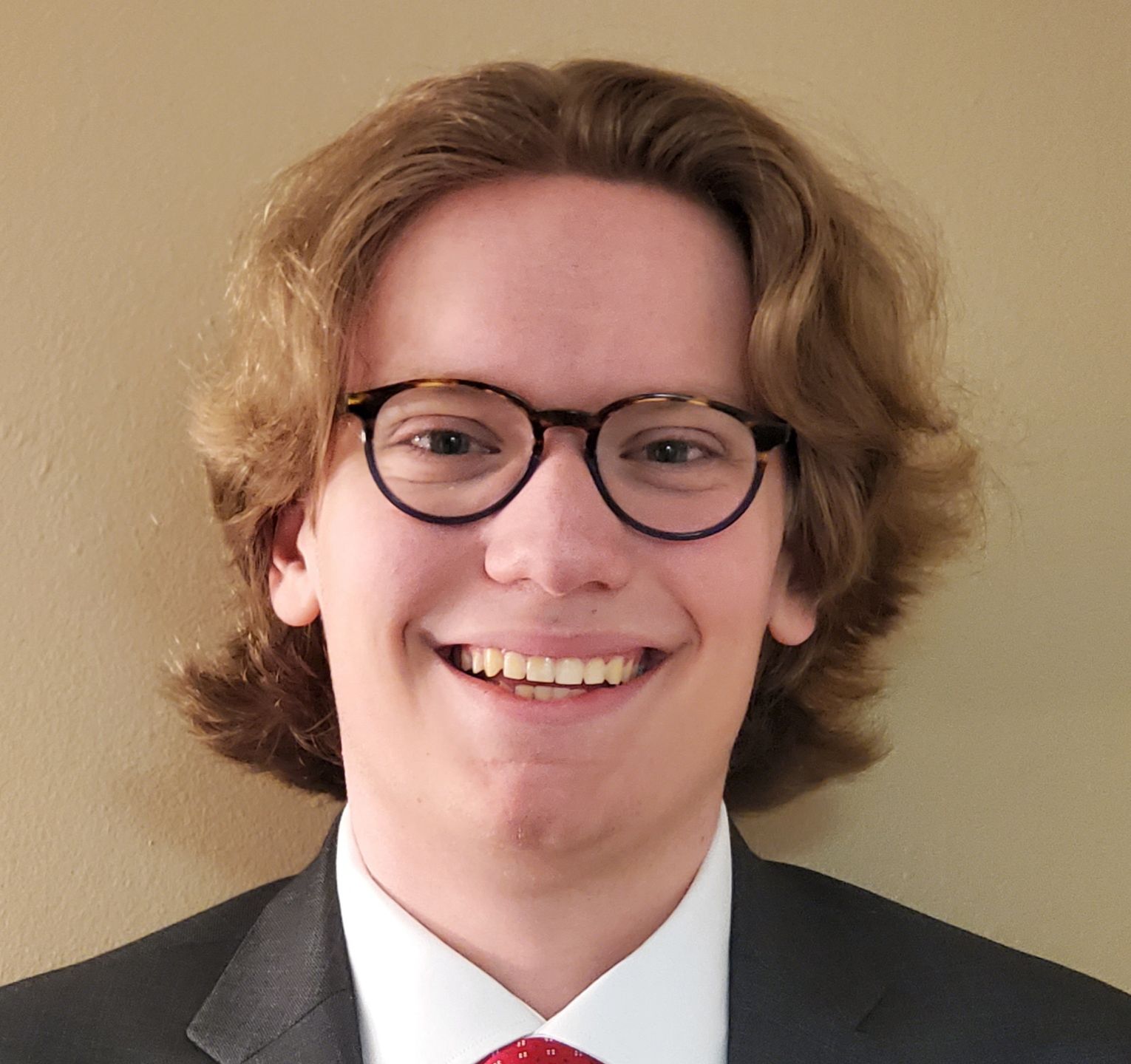 a smiling man wearing eyeglasses 