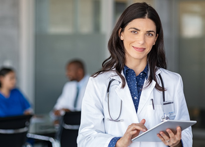 Woman in medical coat carrying clipboard
