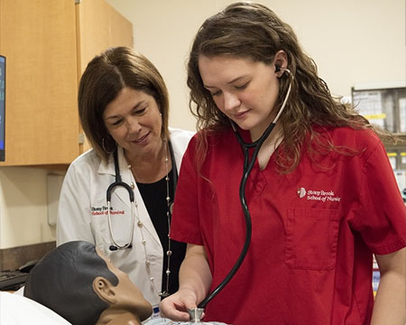 A nursing student using a stethoscope