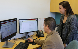 Kristy Bunton  helps faculty member on computer