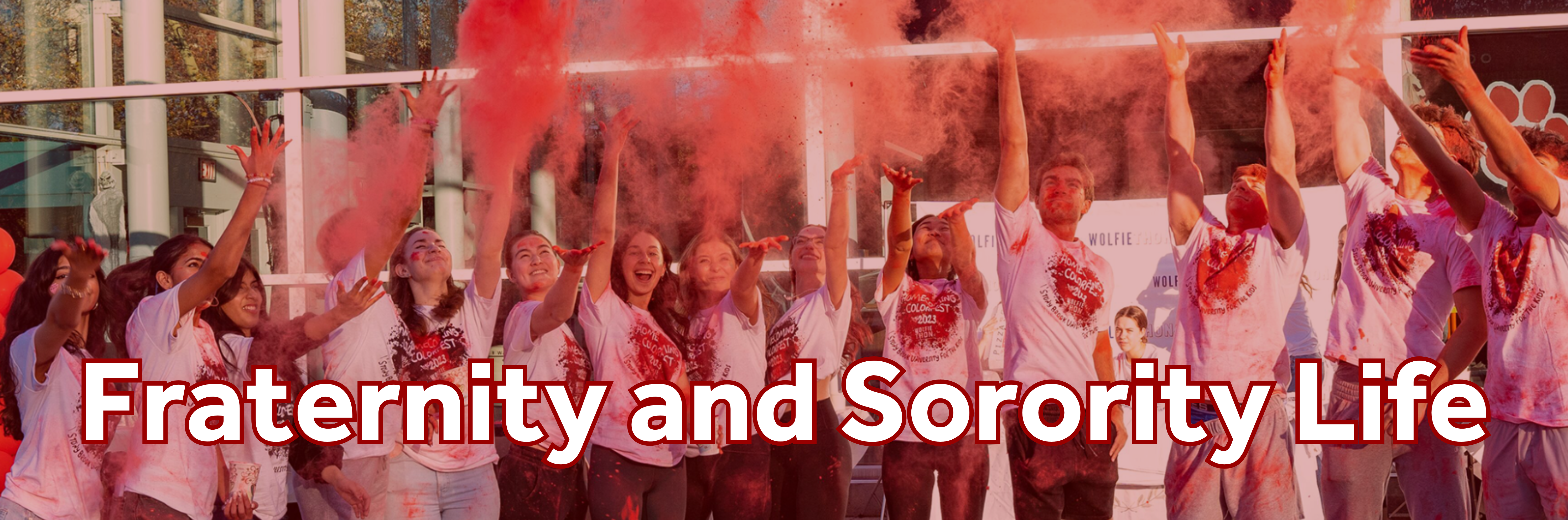 Members of the Fraternity and Sorority Community throwing red colored powder during their Color Fest homecoming event. 